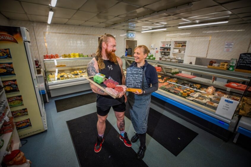 John Beattie and Wendy Donald smiling in butcher's shop