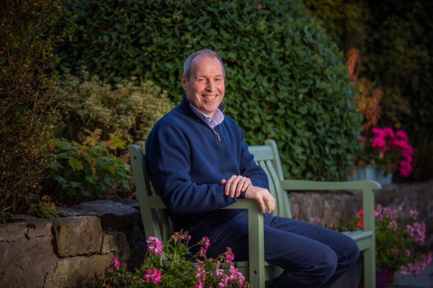 Stewart McDonald sits on a bench in his garden