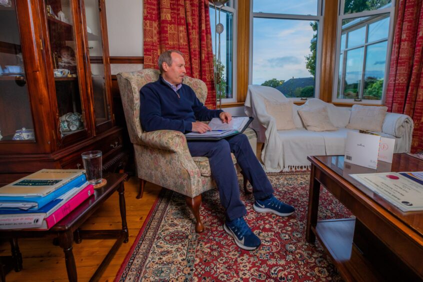 Dundee hypnotherapist Stewart sits down with a folder on his lap