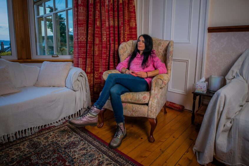 Gayle sits in chair while she chats through her fear of spiders. 