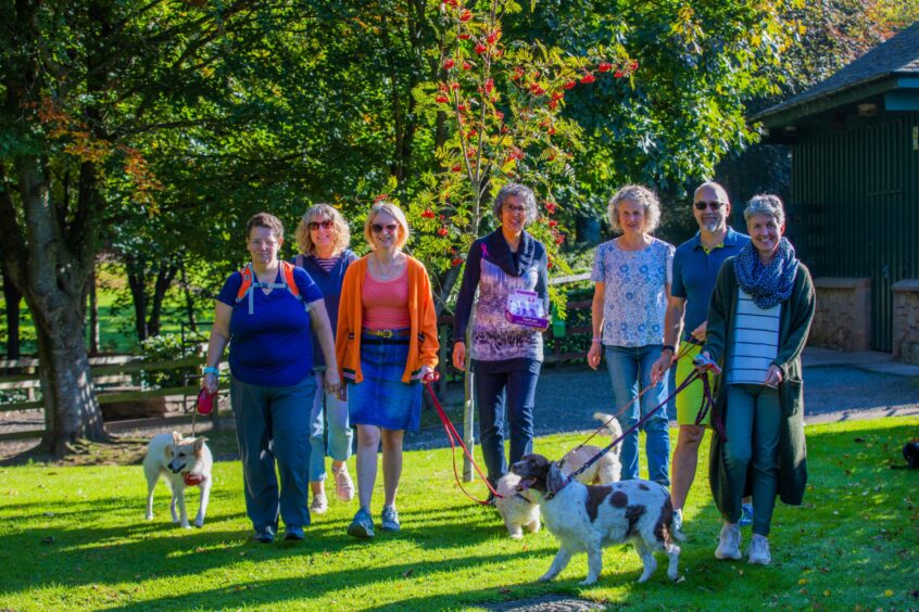 Image shows: Rachel Weiss of Menopause Cafe with her colleagues from Rowan Consultancy. The staff have met for a walk on a sunny autumn day and some have brought their dogs along.