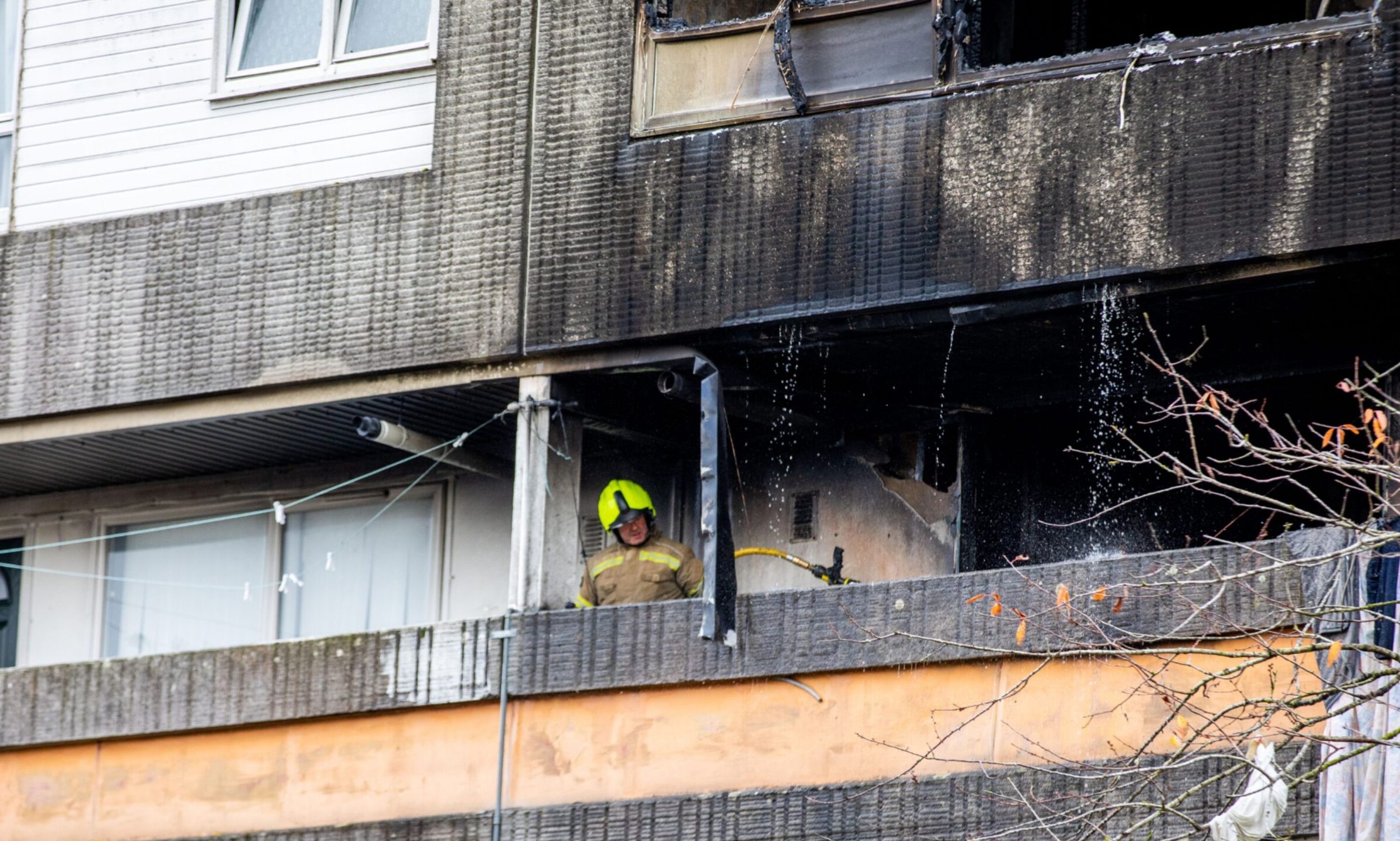 A firefighter outside the burnt-out flat at Abbotsford Court. Image: Steve Brown/DC Thomson