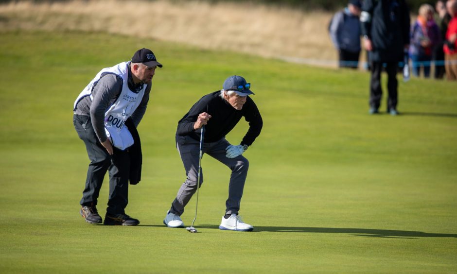 Michael Douglas checking out his options as people get pictures at the Dunhill Cup