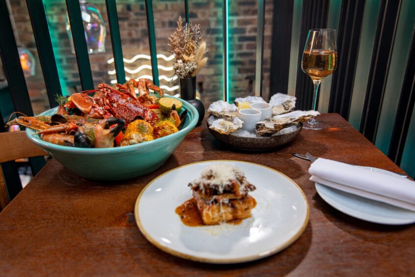 A photo of all the dishes - oysters, wild mushrooms on toast and the seafood boil.