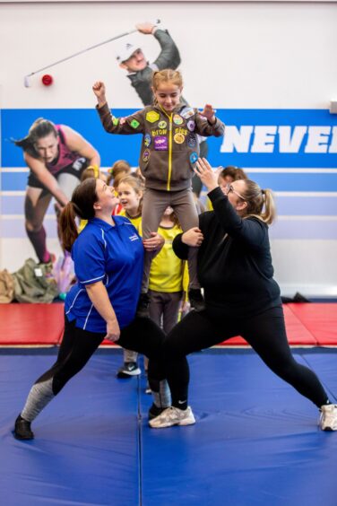 Brownies have a go at cheerleading with Dundee Tribe Cheerleaders at Girlguiding Dundee Adventure on your Doorstep event at Caird park. 