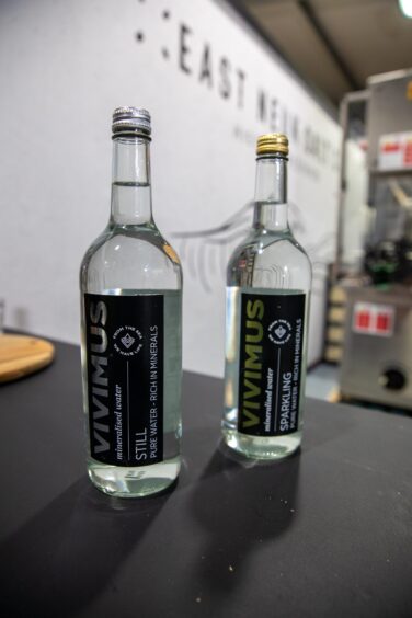 Two glass bottles of Vivimus Water.