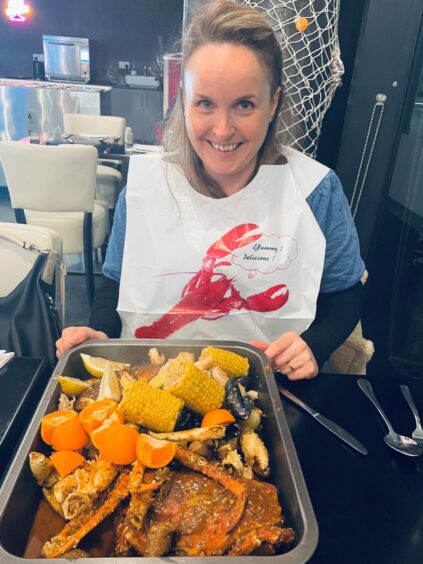 Food and drink writer Rachel wearing a plastic bib ready to tuck into the boil in the bag dish.