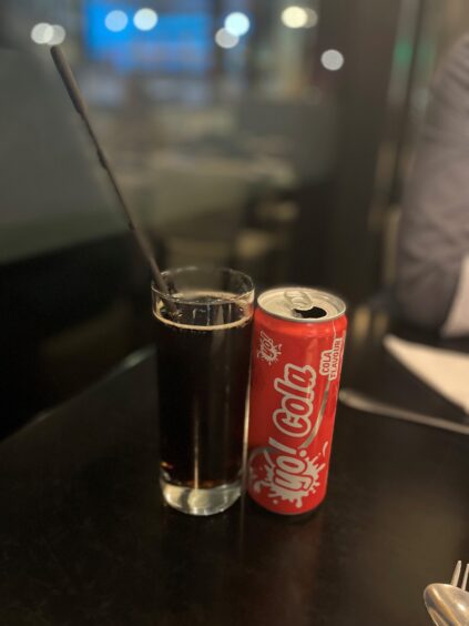 a photo of a can of Yo! cola and a glass with a straw in it.