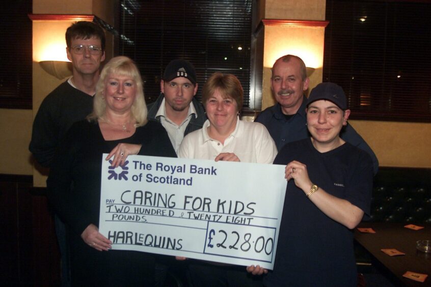 DJ Gary Muircroft accepts the cheque at the pub, joined by supporters