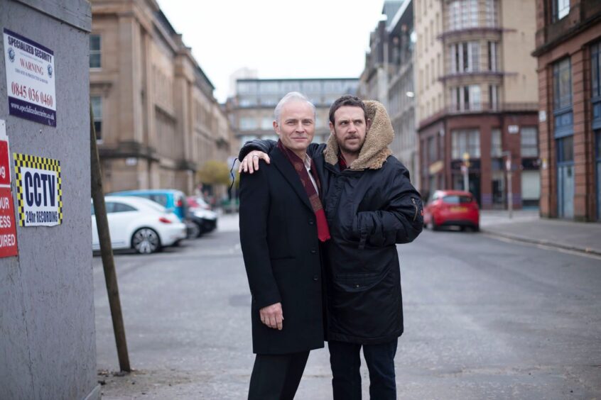 Mark Bonnar and Jamie Sives on set - a city street - during filming.