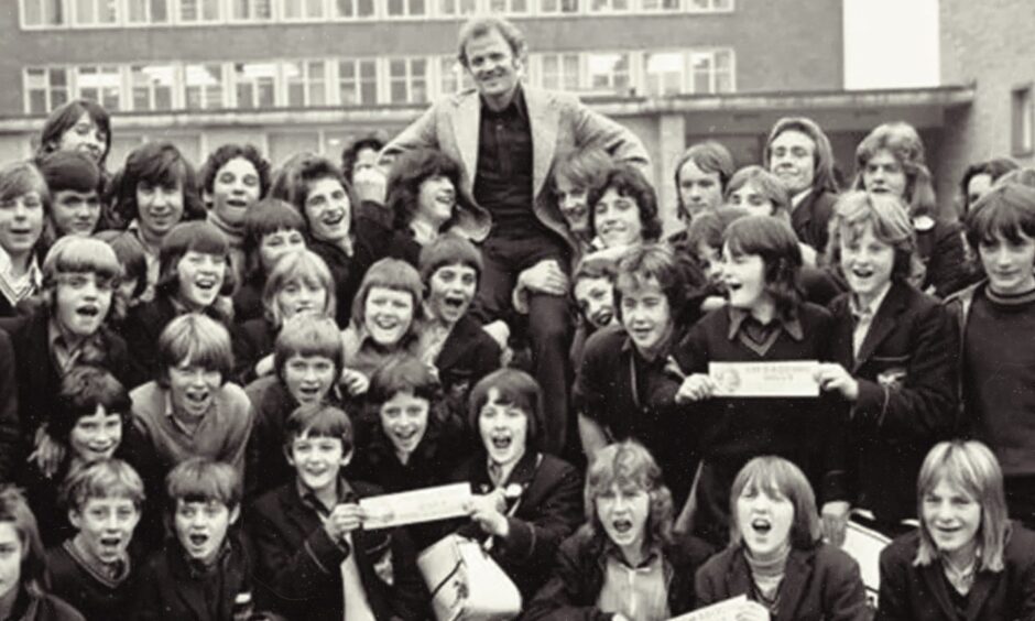 Billy Bremner lifted shoulder high in the playground with pupils in October 1973.