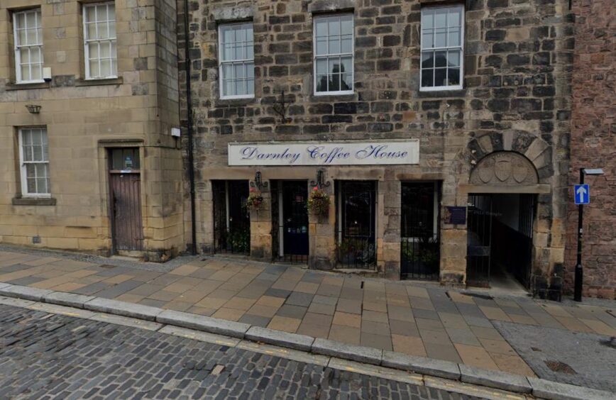 Exterior of Darnley Coffee House in Stirling: a historic stone building on a cobbled street with a white sign.