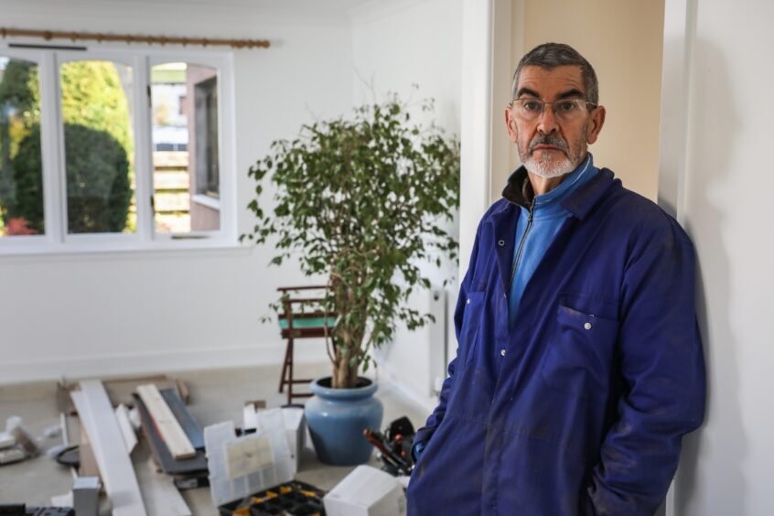 David Scott hopes to move back in to his flood-hit Brechin home in November. The weeping fig tree behind him sprang back to life, giving him a glimmer of hope. Image: Mhairi Edwards/DC Thomson.