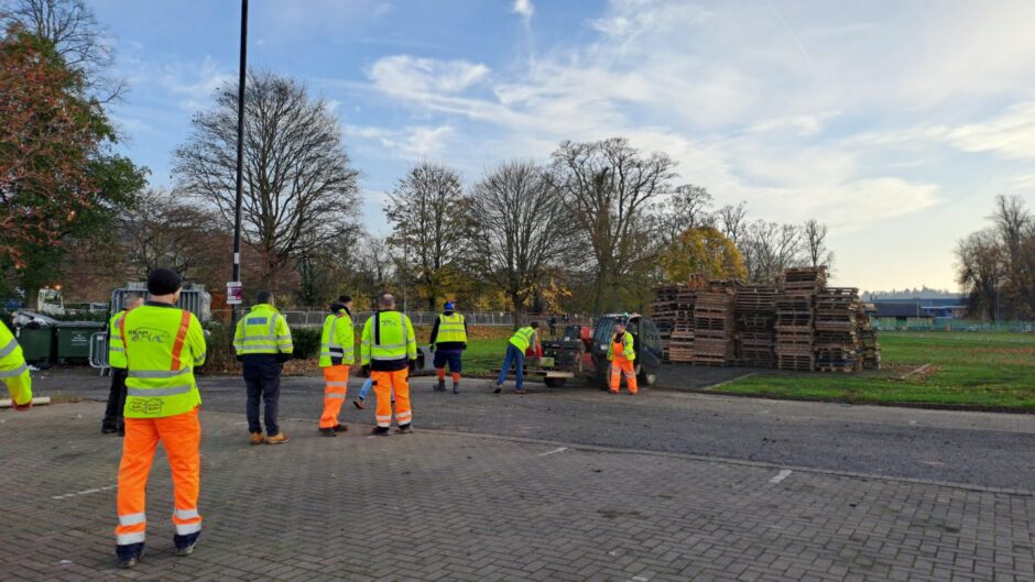 Bonfire being built from wooden pallets