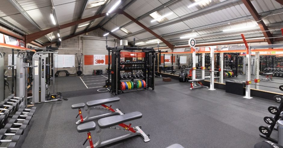 The current lay out of the gym floor with benches, mirrors and weights around the wall.