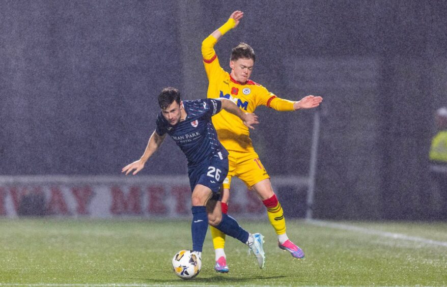 Lewis Stevenson holds off an Ayr United challenge to stay on the ball for Raith Rovers.