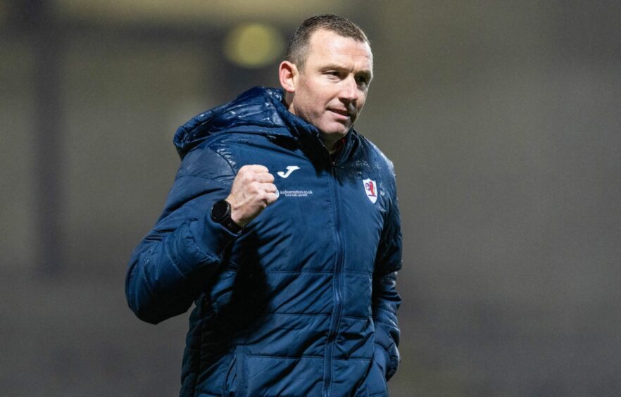 Raith Rovers boss Neill Collins shows a clenched fist in delight.