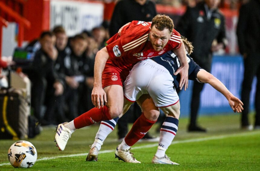 Dundee's Lyall Cameron and Aberdeen defender Nicky Devlin tussle for the ball.