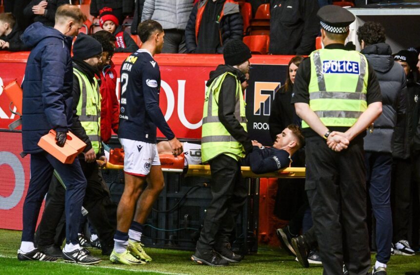 Finlay Roberston leaves the field on a stretcher after Dundee's defeat.