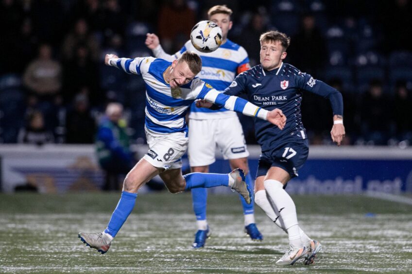 Raith winger Lewis Gibson tussles for the ball with two Morton opponents.