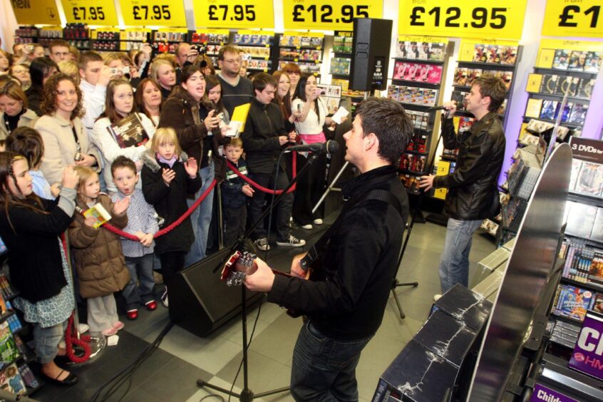 Shoppers look on as The MacDonald Brothers perform at HMV in October 2007. 