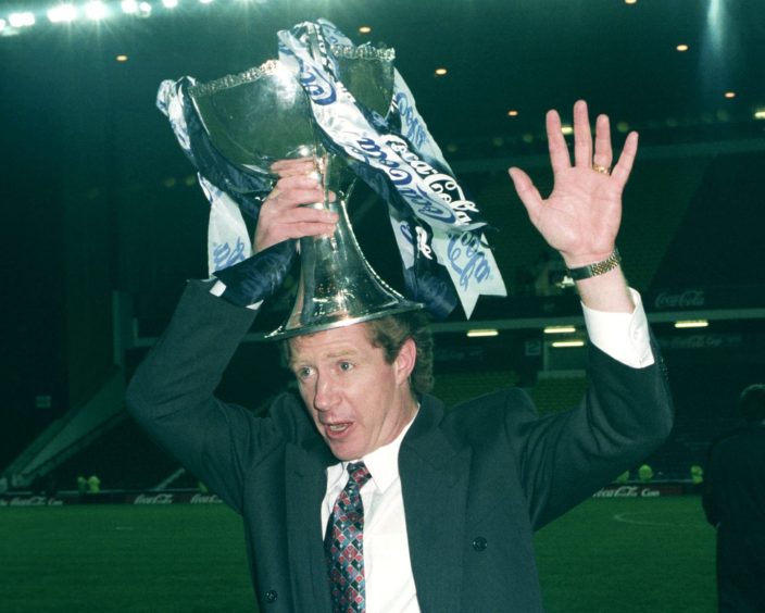 Jimmy Nicholl places the Coca-Cola Cup on his head after Raith's victory over Celtic. 