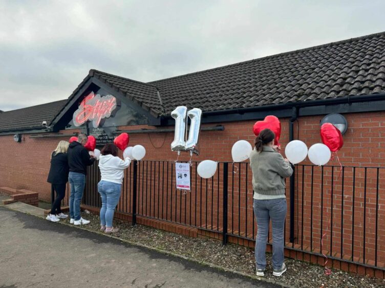 The Allan Bryant balloon tribute fixed to railings by family members. 