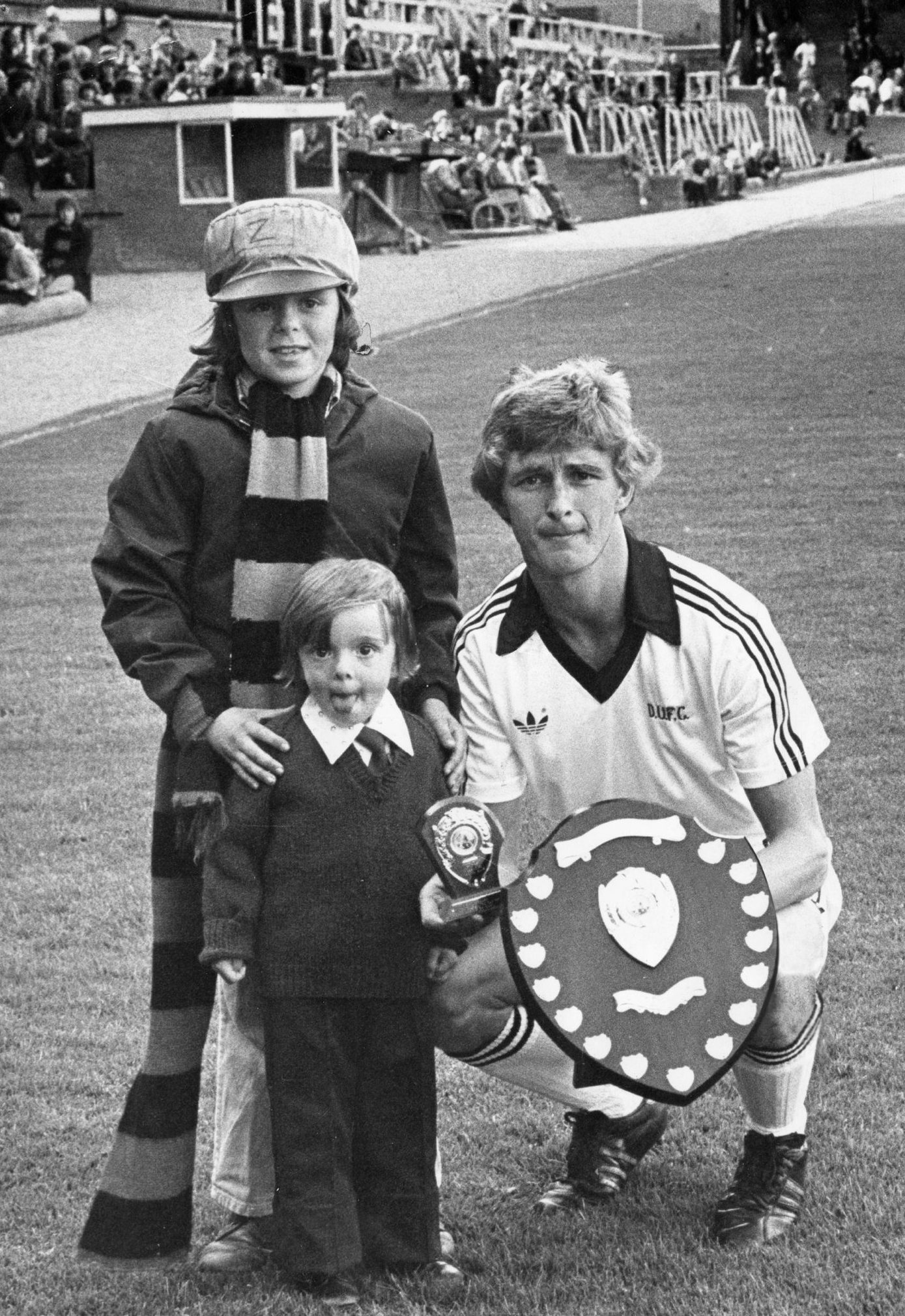 Two youngsters pose for pic beside Hegarty on the Tannadice pitch as he receives two shields for being Dundee United Travel Club's player of the month in September 1977.