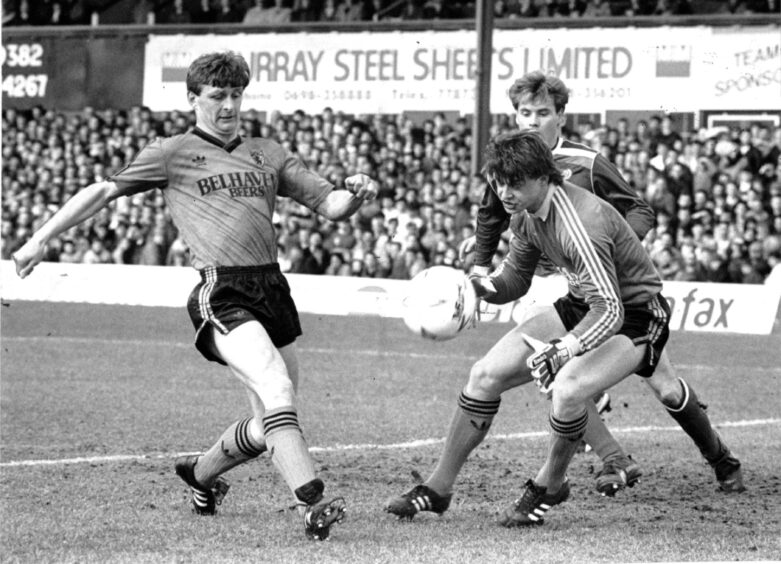 Paul Hegarty clears the ball in a Dundee derby in March 1988, as the Dundee United goalie and Dundee FC striker Tommy Coyne look on in the six-yard box