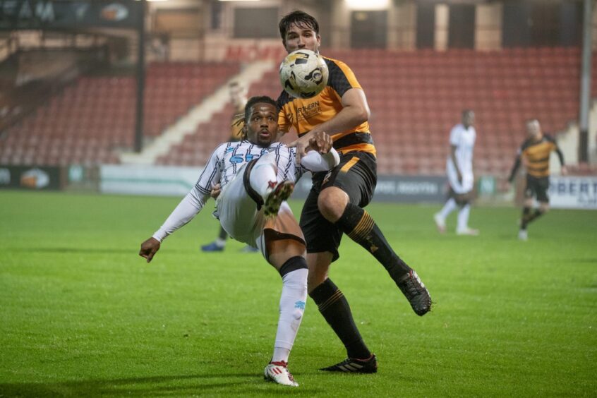 Dapo Mebude leans back as he stretches for the ball during a game for Dunfermline against Alloa Athletic.