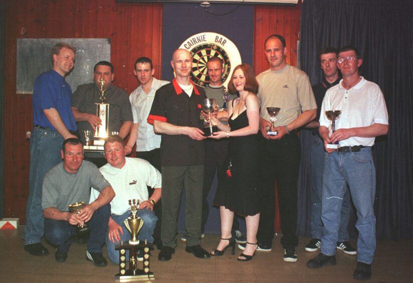 Arbroath and District Winter Darts League get their prizes in front of dart board at the Cairnie Bar in May 2000