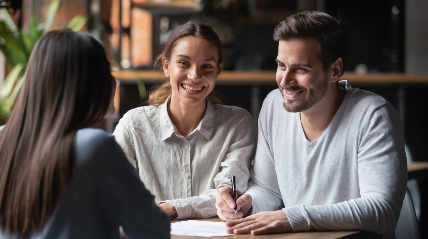 Smiling young husband and wife with financial adviser