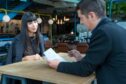 Human resource manager interviews an applicant while looking at her resume, a scenario where a salary guide is useful