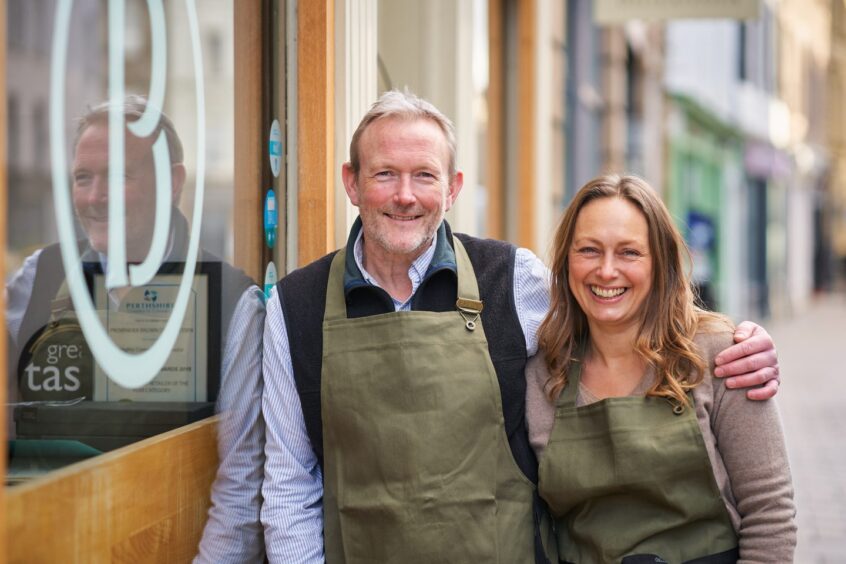 smiling couple stands outside a shop called Provender Brown where you can do some Christmas shopping in Perth