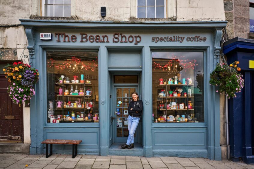 young woman stands outside the facade of The Bean Shop in Perth