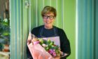 woman holds a bouquet of flowers at a florist where you can do some Christmas shopping in Perth