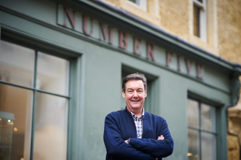 owner stands outside the facade of Number Five jewellery shop