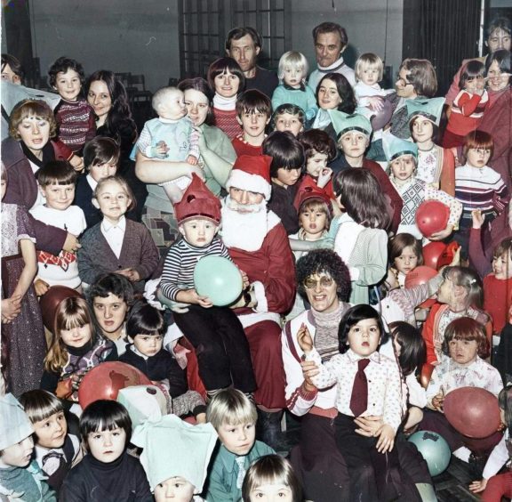 Santa Claus is surrounded by children and adults at a party organised by the Whitfield Residents' Association in 1977