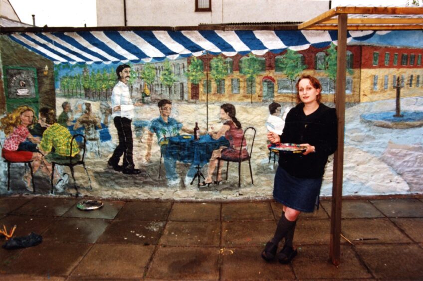 Artist Janet Twiselton, with the 20 foot by six-foot wall painting showing a café scene she did for friends in Fisher Street, Broughty Ferry.