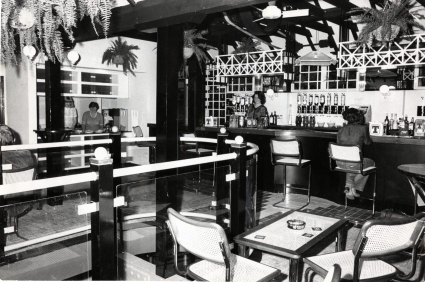 a woman works behind the bar and another woman sits at the bar of Dundee pub Da Vinci's