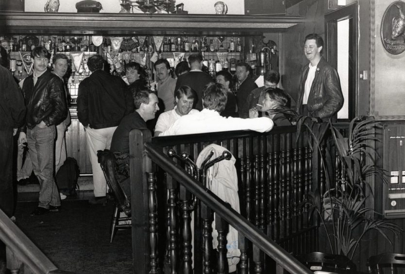 drinkers at the bar and sitting at a table in Dundee pub Smugglers in October 1988