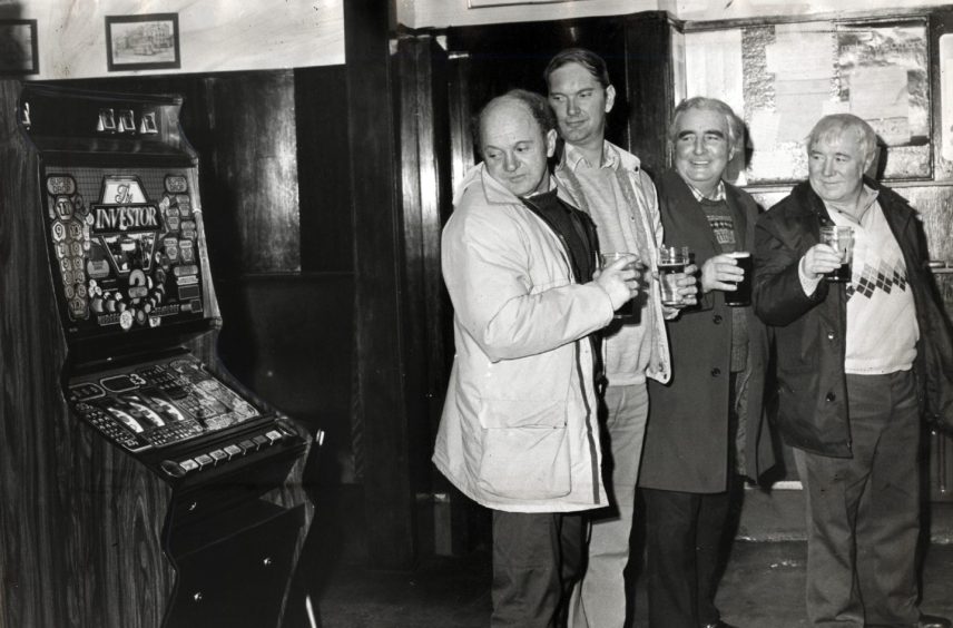 Regulars look suspiciously at the bandit in December 1984. 