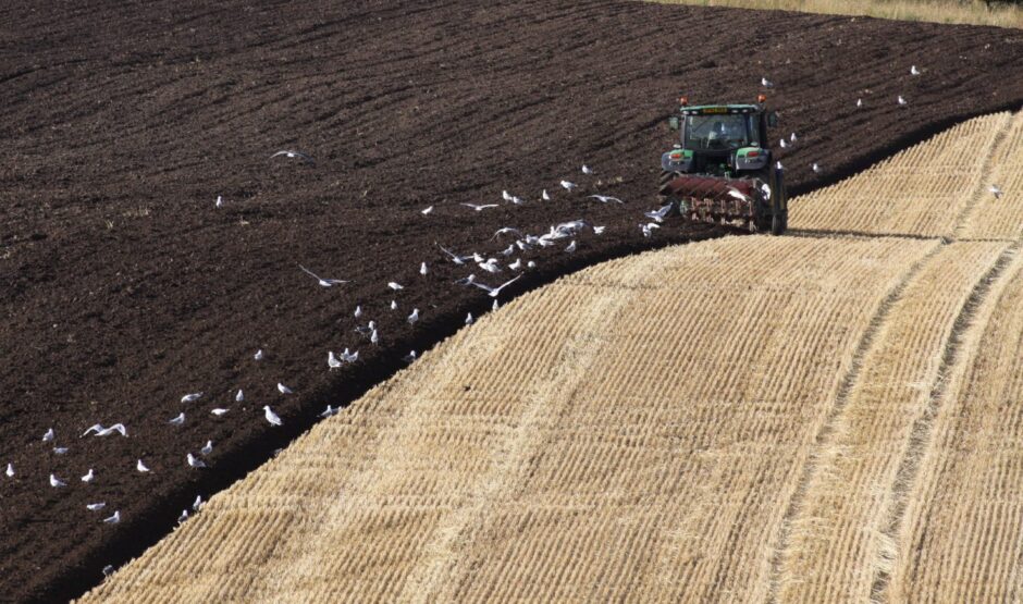 Tractor and plough hard at work in the fields on the outskirts of Dundee.