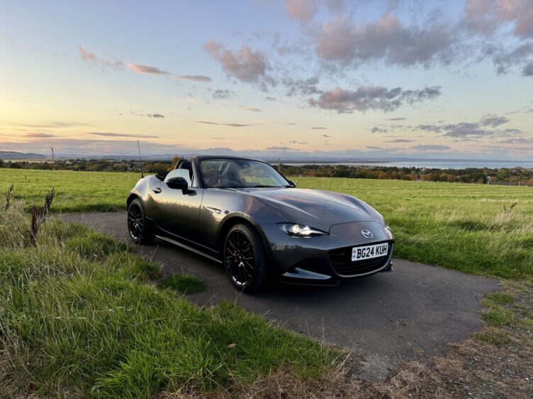 The Mazda MX-5 with a field in the background