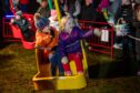 A wave from Ronnie and Violet Sievewright on one of the funfair rides. Image: Kim Cessford / DC Thomson