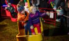 A wave from Ronnie and Violet Sievewright on one of the funfair rides. Image: Kim Cessford / DC Thomson