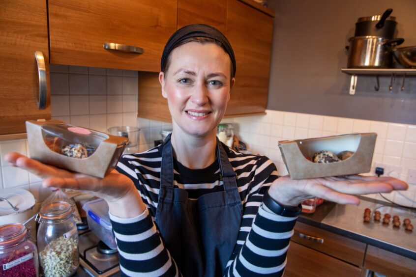 Staci Clarke holding a box of Bliss Bites in each hand.