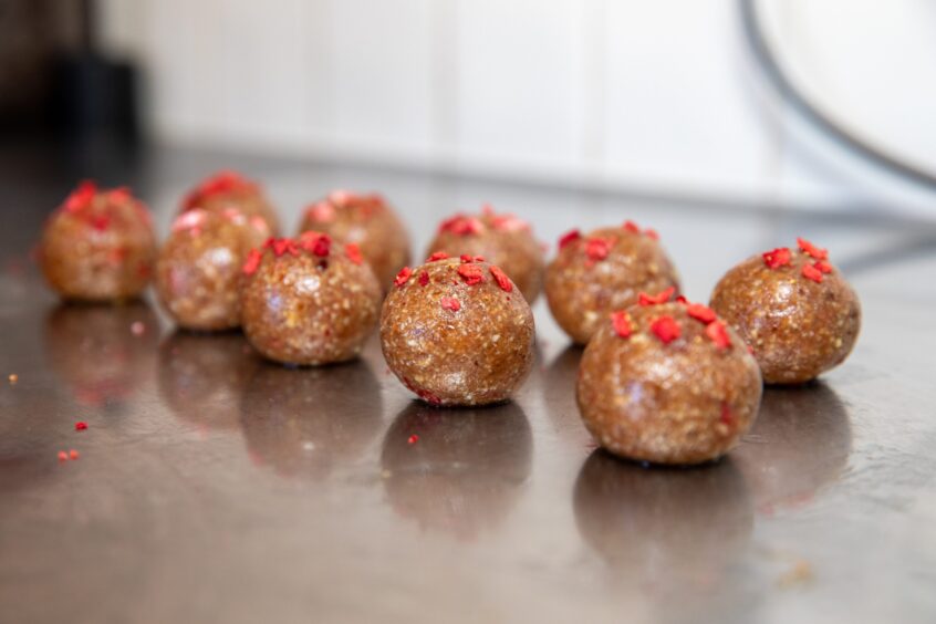 Staci's strawberries and cream flavoured Bliss Bites balls. They are pale brown with freeze-dried strawberry pieces on top.