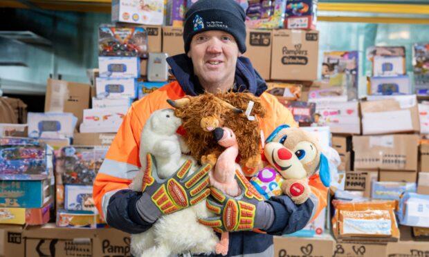 Warehouse worker Stuart Oliver sorts toys inside The Big House Multibank warehouse in Lochgelly. Image: Kenny Smith/DC Thomson.