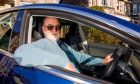 Mike Perry at home in Perth with his Tesla car. Image: Kenny Smith/DC Thomson.